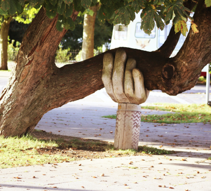 carved hand holding a tree up