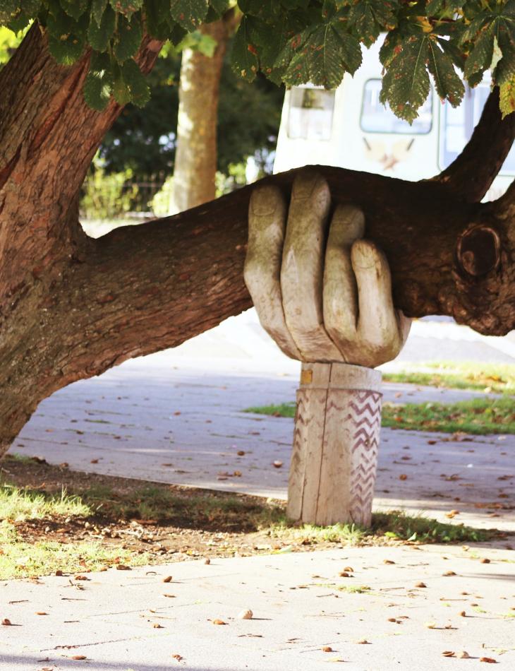 carved hand holding a tree up
